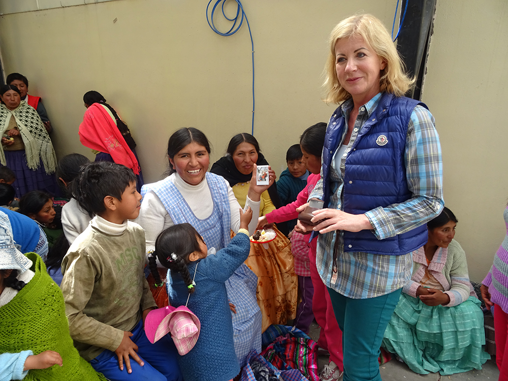 Die Kinder reißen sich um die Bilder, die die Sofortbildkamera von Ingrid Weinberger auswirft.